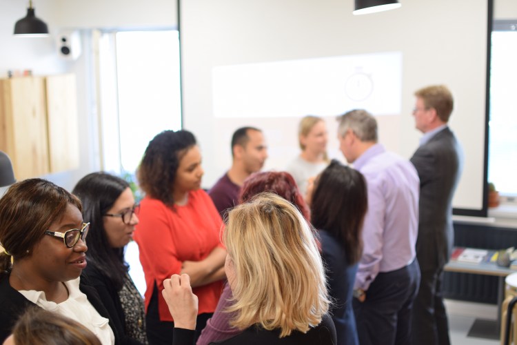 People of many nationalities in two rows facing each other speed-networking